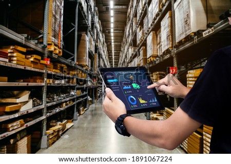 Smart warehouse management system.Worker hands holding tablet on blurred warehouse as background Royalty-Free Stock Photo #1891067224