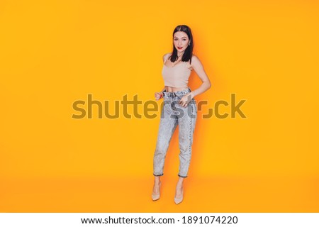 Young woman standing in front of a yellow background. Excellent advertising photo for a banner. Health care. Do-it-yourself makeup at home.