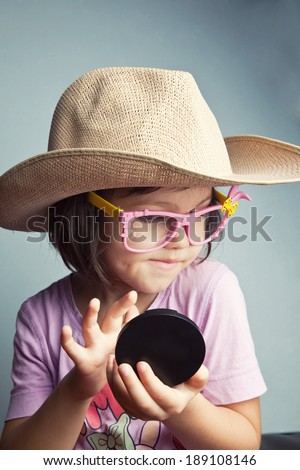 Child preens in a cowboy hat