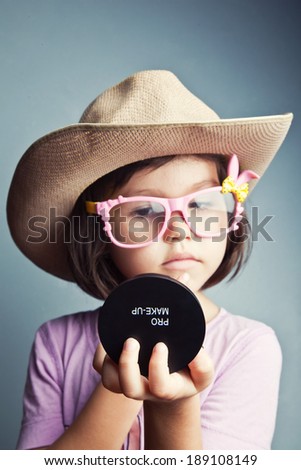 Child preens in a cowboy hat