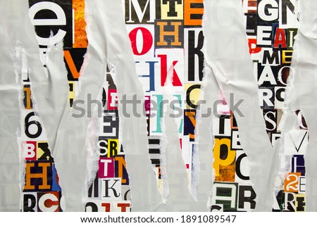 Torn and crumpled grey paper on colorful abstract collage from clippings with newspaper magazine letters and numbers. Ripped gray paper glued on alphabet letters cutting from magazine background.