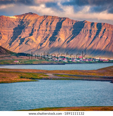 Long focus picture. Amazing summer view Grundarfjordur town with Kirkjufell Mountain on background. Unbelievable evening scene of Iceland, Europe. Beautiful summer scenery.

