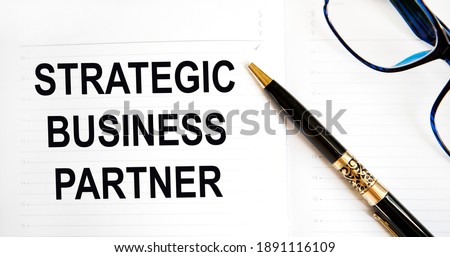 In the diary text STRATEGIC BUSINESS PARTNER, next to the pen and glasses.