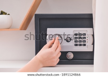 Woman opening modern safe indoors Royalty-Free Stock Photo #1891124866