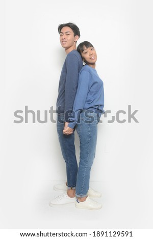 Relationship concept.young couple back to back posing on a white background. 

