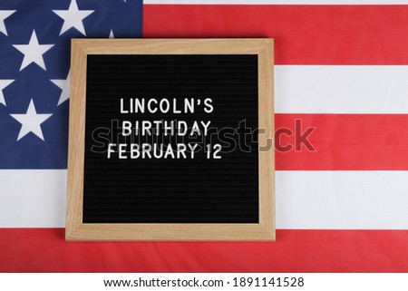black letter board with text Lincoln's Birthday and American flag . top view flat lay copy space 