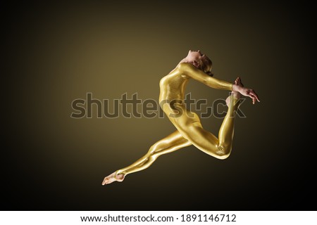 Jumping Woman dance in golden Body Suit. Ballerina back bend Profile view. Black Background