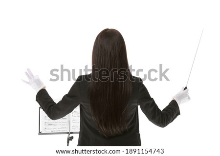 Young female conductor on white background Royalty-Free Stock Photo #1891154743