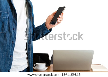 Man asian businessman using laptop, tablet, mobile phone, coffee cup on desk table.He wearing blue shirt and 
stand sideways wooden table in home office on isolated white background with copy space.