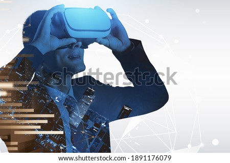 Portrait of young European businessman using VR glasses in blurry night city. Concept of hi tech and communication. Toned image double exposure of graphs