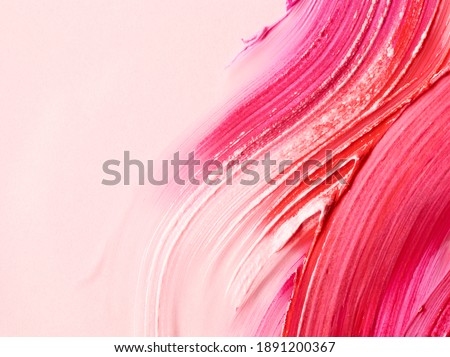 Smudged lipsticks over light pink background with place for text Royalty-Free Stock Photo #1891200367