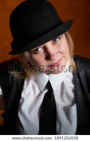 Portrait of fat plump chubby middle-aged woman with hat. Model posing in male style in the Studio.