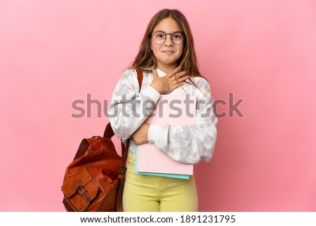 Student little girl over isolated pink background surprised and shocked while looking right