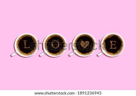 Four cups with espresso coffee with froth and the inscription love on a pink background horizontally. Valentine's day greeting card, heart