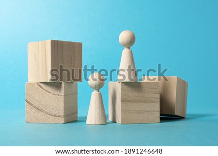 Wooden figures as people. Concept of construction and destruction. blue background
