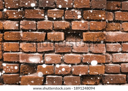 
old red brick wall in snowflakes