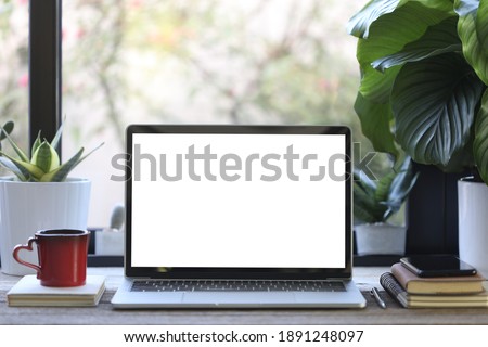laptop mock up white blank screen with phone and coffee cup and plant pot on wooden table