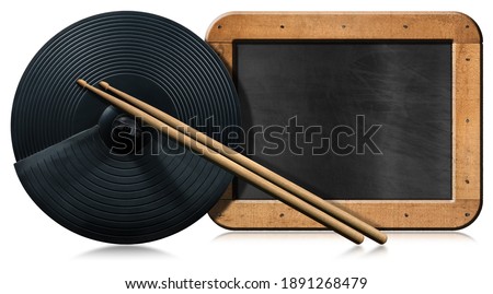 Black cymbal of an electronic drum kit, a pair of wooden drumsticks and an empty blackboard with copy space, isolated on white background with reflections. Percussion instrument concept.