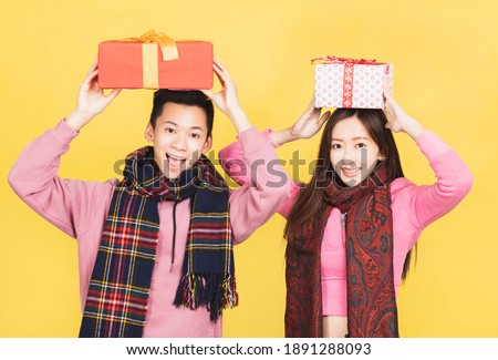 happy asian couple showing the gifts and celebrating chinese new year 