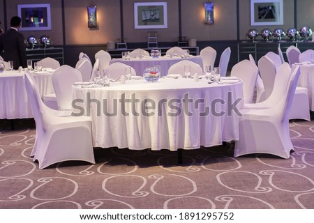 Decoration of tables and chairs in a hotel interior. Whtie textile. Empty table and chairs.