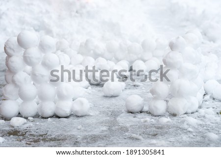 There are many round snowballs in the snow. Winter fun. Abstract new year christmas background. Copy space.