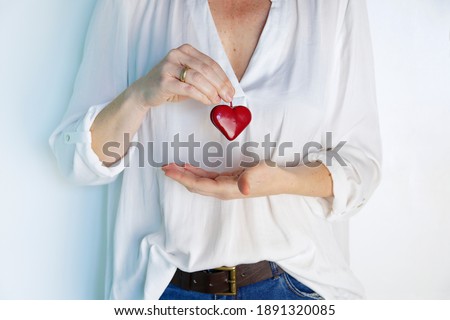 Woman hands showing a red love heart. Love concept.