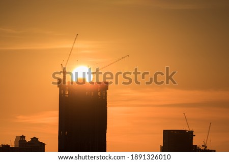 A cityscape of buildings under sunset with colorful cloudy sky