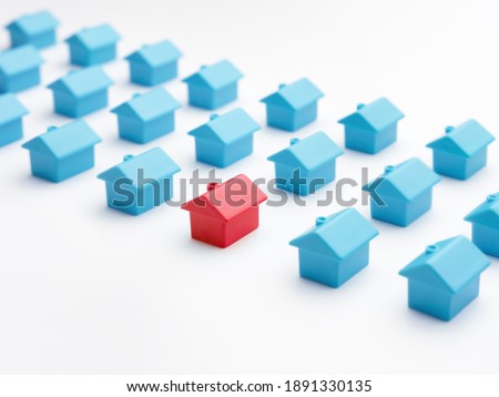 Home choice or selection property and real estate. Red house model among blue toy houses on white color background. Unique house different from group of same type miniature houses. Property marketing Royalty-Free Stock Photo #1891330135