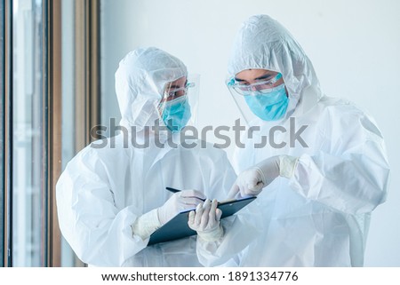Two asian doctor wearing personal protective equipment or PPE working on quarantine patient infected coronavirus (covid-19), Teamwork medical staff during the epidemic crisis coronavirus. Royalty-Free Stock Photo #1891334776