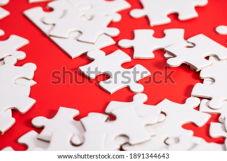 Blank white puzzle pieces on red background
