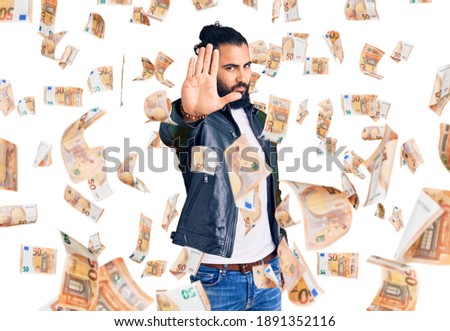 Young arab man wearing casual leather jacket doing stop sing with palm of the hand. warning expression with negative and serious gesture on the face.