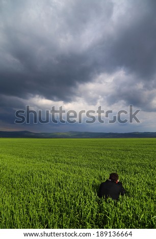 Nature photographer in a green wheat field