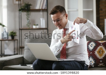 Young businessman working with laptop at office. Businessman sitting on sofa having video call