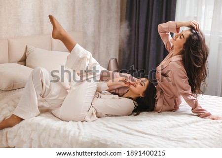 Funny cool young women wear pajamas , best friends ladies having fun together enjoy spa celebration bachelorette hen party in bedroom concept, group portrait Royalty-Free Stock Photo #1891400215