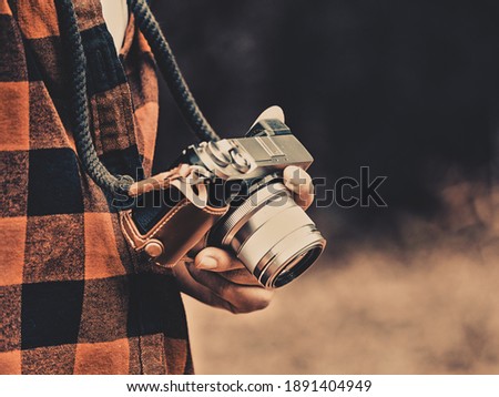 Young woman holds vintage style digital camera