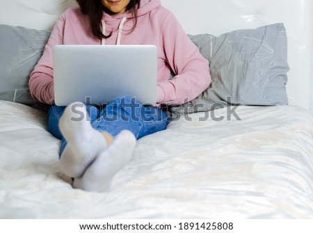 Young woman using laptop in the bedroom. Freelance and home office concept. Selective focus.