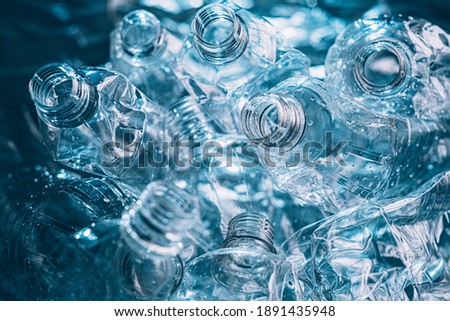 Ocean pollution. Plastic reuse. Waste management. Environmental contamination. Wet clean empty creased bottles pile on blur teal green blue background. Royalty-Free Stock Photo #1891435948