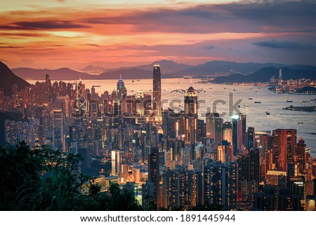 Hong Kong city on dramatic sky at sunset view from mountain.