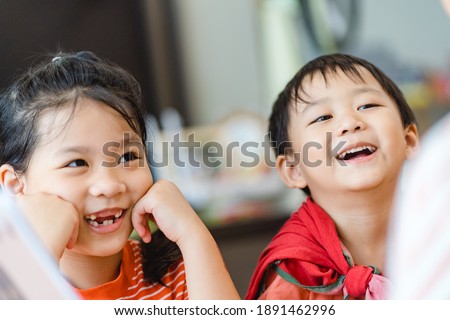 Happy family lockdown activity at home.Asian Mother and children are learning bible sunday school study online for bible story.Mom woman teaches her child.Sibling kids learning at home during covid19. Royalty-Free Stock Photo #1891462996