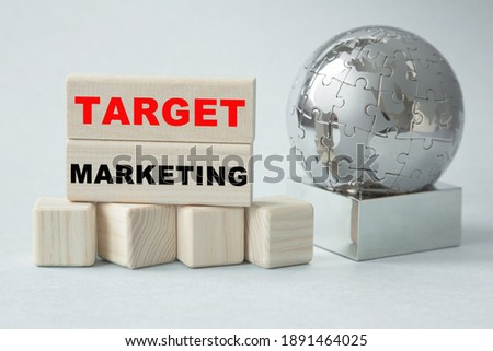 Text TARGET MARKETING. Globe and wooden cubes on a gray background. The concept of world business, marketing, finance.