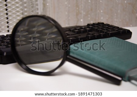 magnifier, green notepad, keyboard lie on a white background. financial items. office. High quality photo