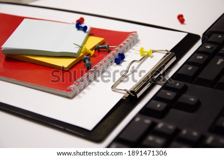 paper clips, red notepad, keyboard lies on a white background. High quality photo