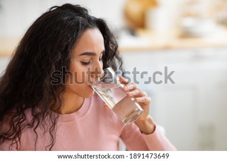 Healthy Liquid. Beautiful Brunette Woman Drinking Mineral Water From Glass In Kitchen, Thirsty Young Lady Enjoying Refreshing Drink At Home, Closeup Portrait With Selective Focus, Free Space Royalty-Free Stock Photo #1891473649