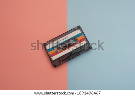 audio cassette on pink and light blue background