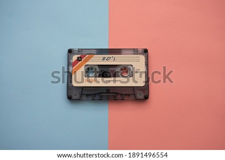audio cassette on pink and light blue background