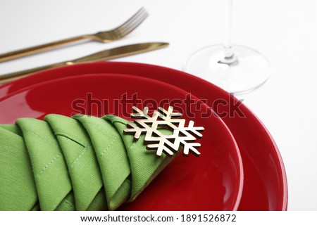 Festive table setting with green napkin folded in shape of Christmas tree on white background, closeup
