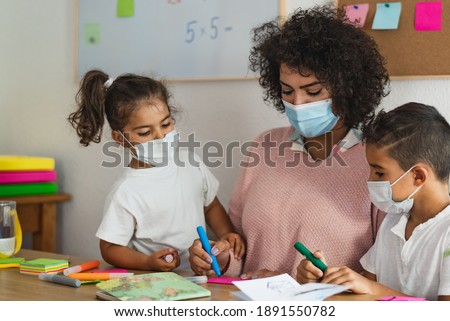 Teacher with children wearing face mask in preschool classroom during corona virus pandemic - Healthcare and education concept Royalty-Free Stock Photo #1891550782