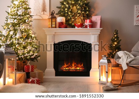 Beautiful fireplace, Christmas tree and other decorations in living room. Interior design