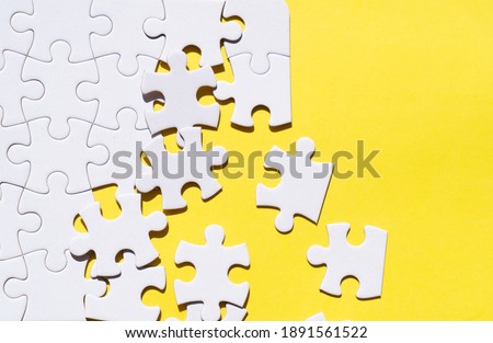 jigsaw puzzles unsorted pieces on illuminating yellow background