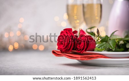 Valentines day table setting  red roses and champagne glasses on concrete background. Valentine 's greeting card - Image Royalty-Free Stock Photo #1891562413